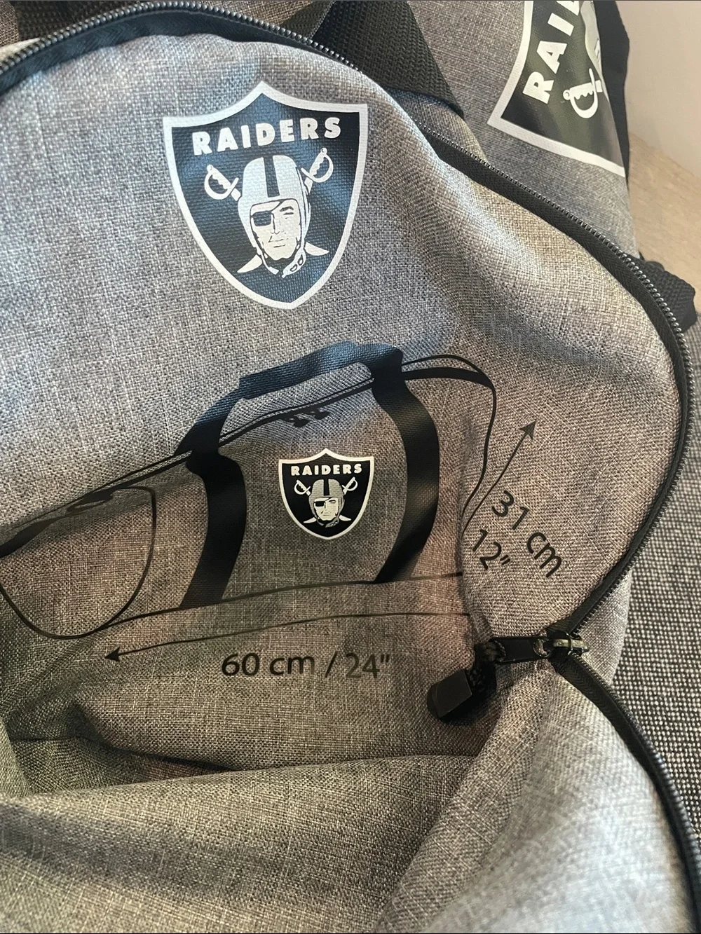 Northwest Gray Duffel Bag with Black Straps and Raiders Logo